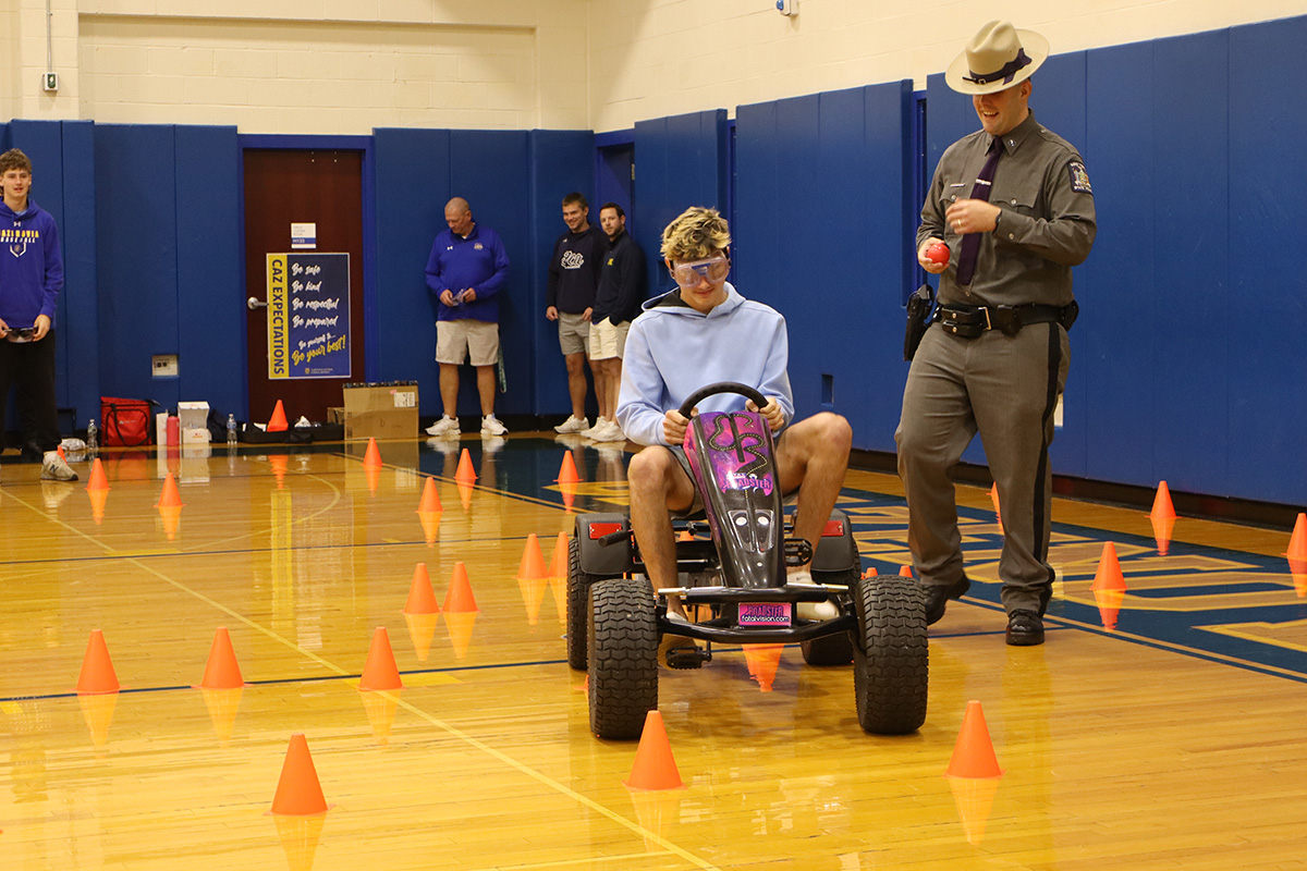 student wears drunk driving simulation glasses and tries to drive around traffic cones